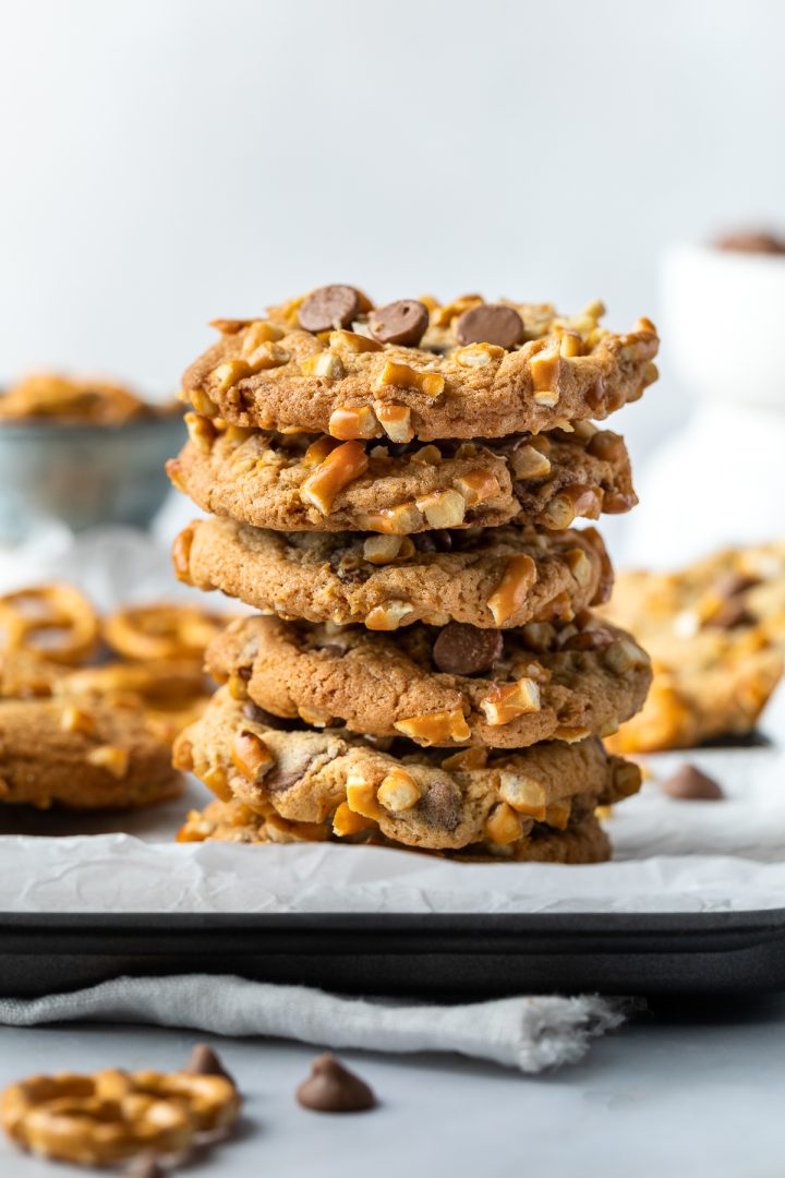 A stack of 5 chocolate chip cookies on a baking tray.