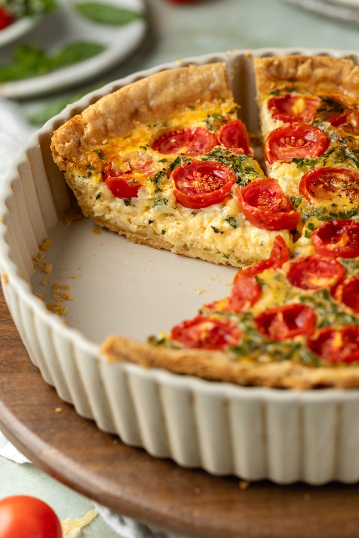 Side view of a piece on quiche in the serving dish.