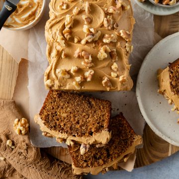 The top of a coffee and walnut cake with some slices taken off to show the light texture of the cake.