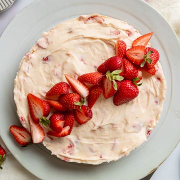 A no bake strawberry cheesecake on a plate topped with fresh strawberries.