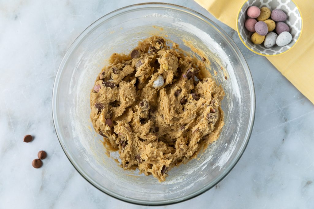 The chocolate chips and mini eggs stirred into the cookie dough.