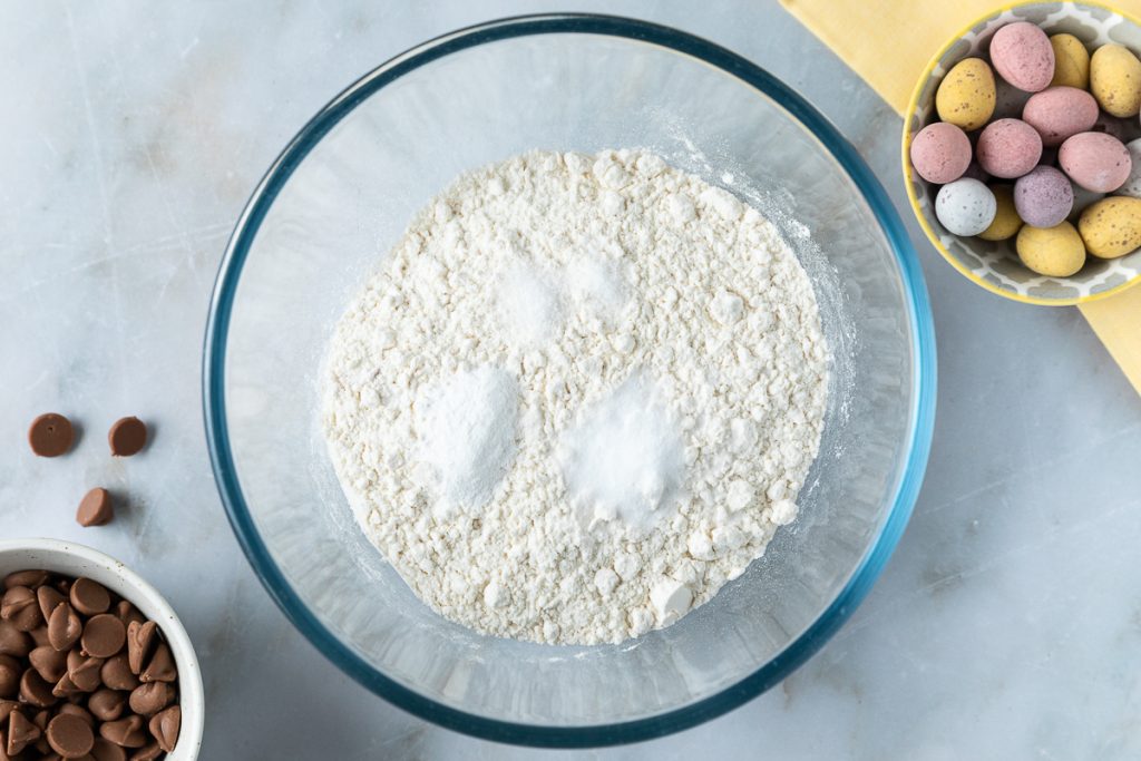 Flour, baking soda, baking powder and salt in a bowl.