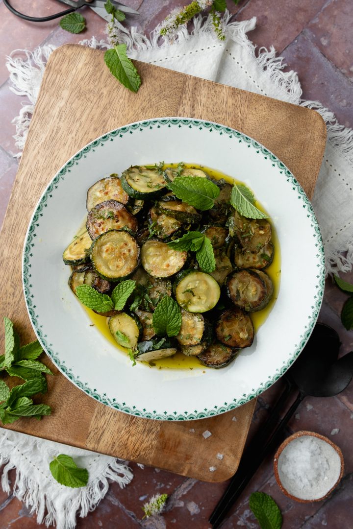 A plate of Italian fried courgettes (zucchini alla scapece) on a wooden board.