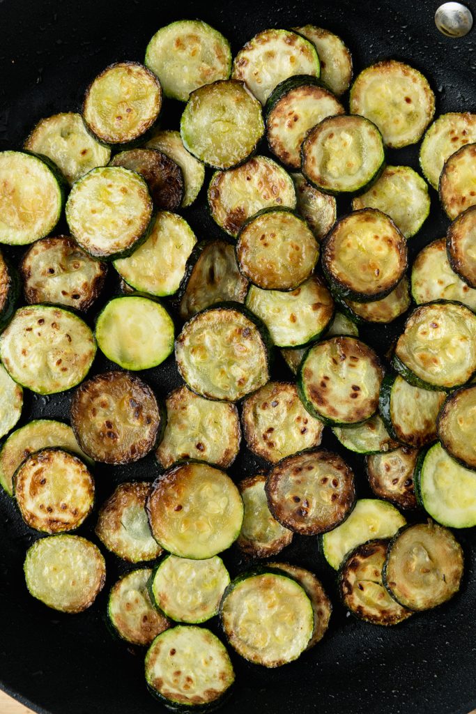 The fried zucchini / courgettes in a pan.