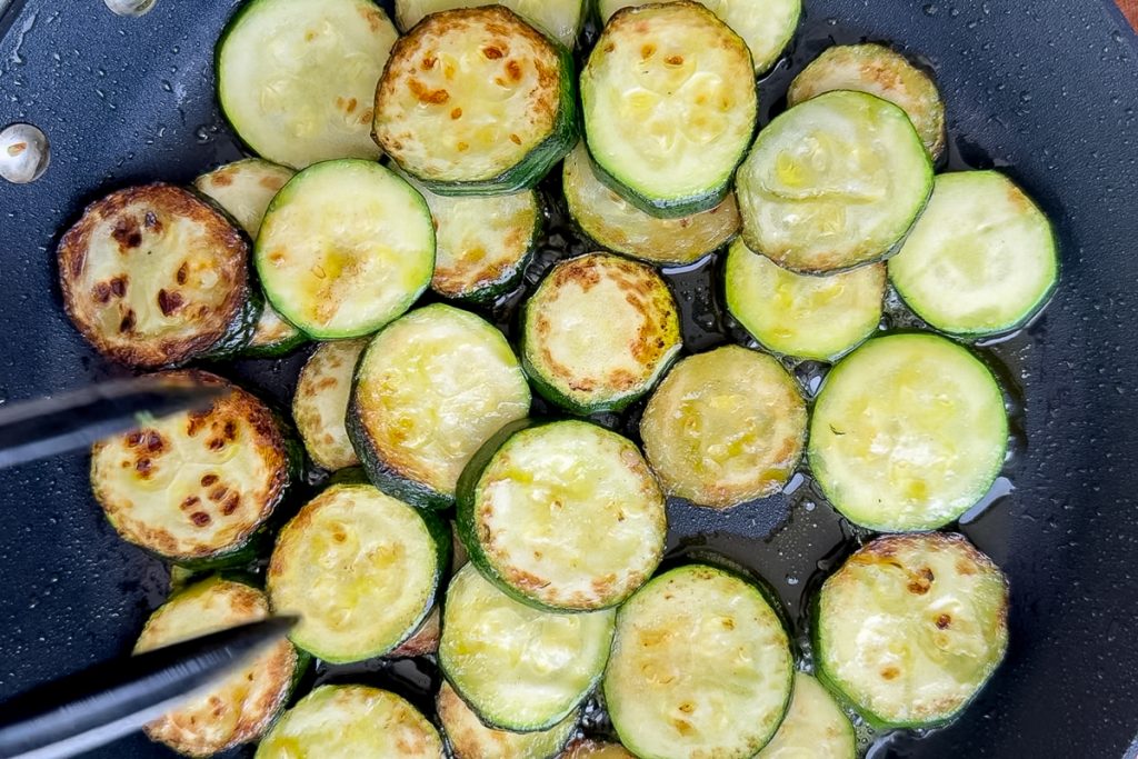 The golden fried slices of courgette (zucchini) in the pan.
