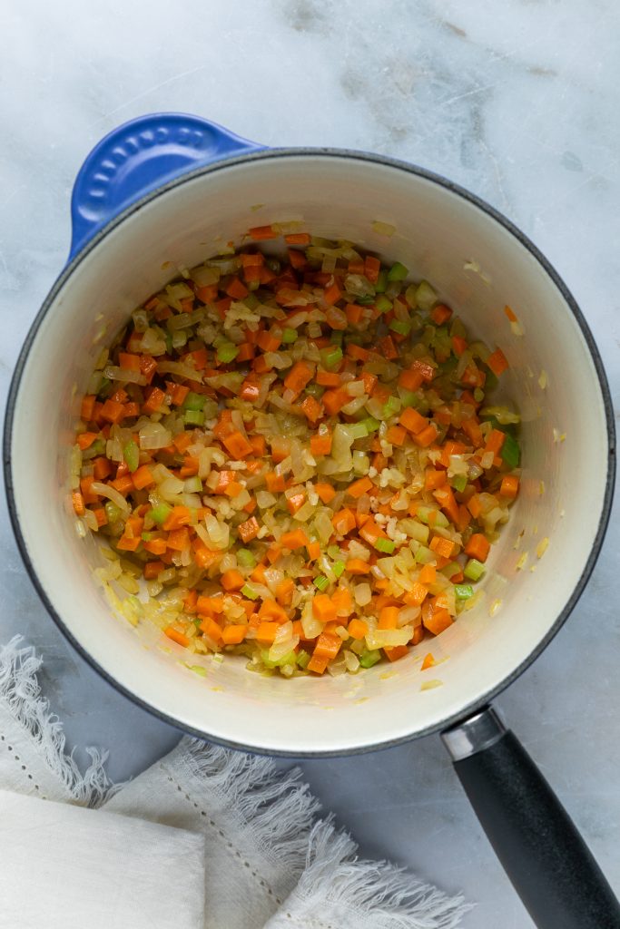 The softened vegetables in a pan.