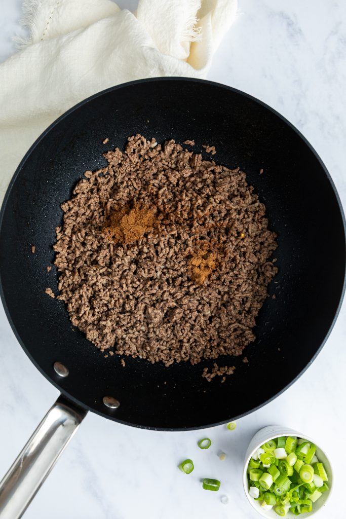 Spices added to the beef mince in the pan.