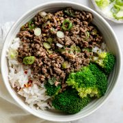 A bowl of stir fried beef mince served with broccoli and rice.
