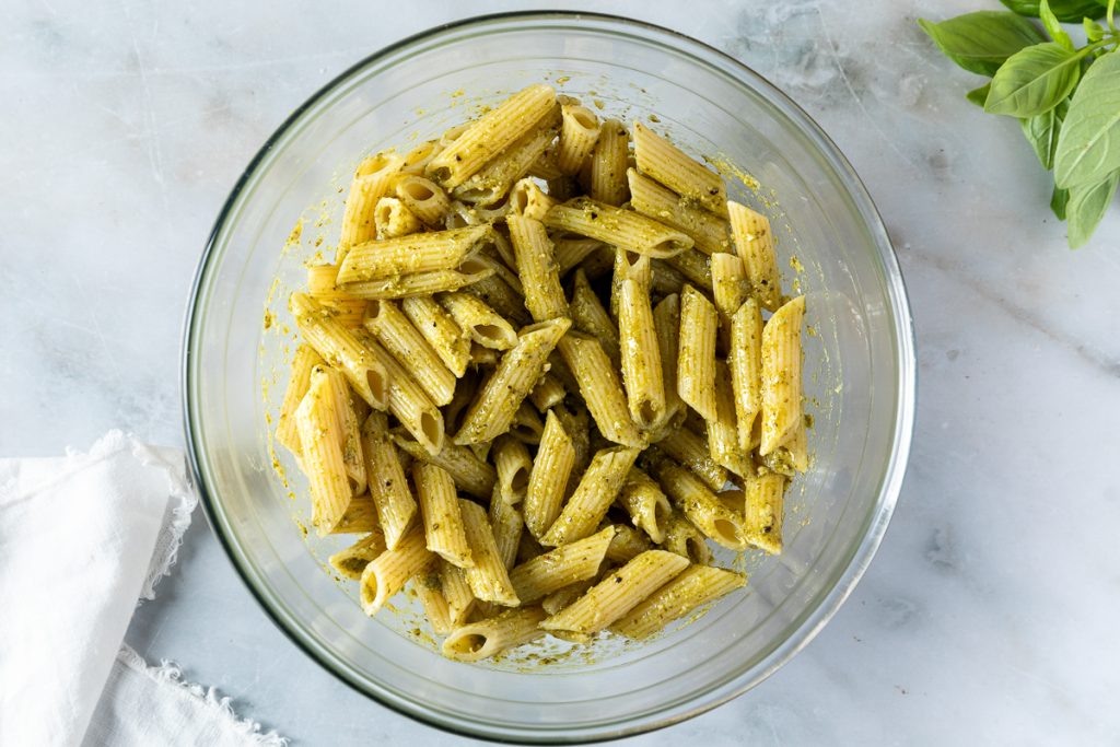 The pesto mixed with the cooked pasta.