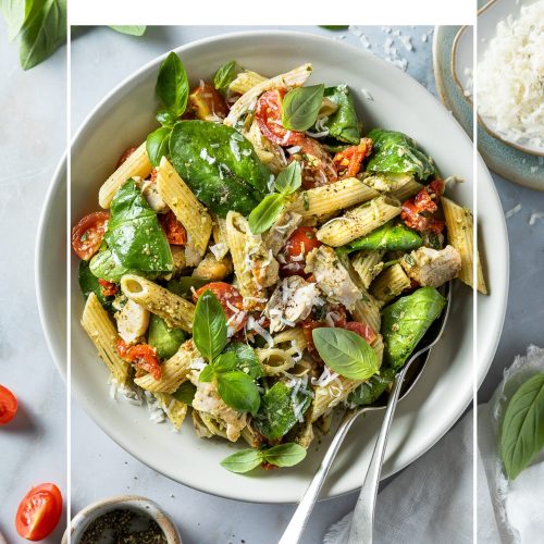 A bowl of chicken pasta salad with pesto and spinach, with text overlay to create a pin for Pinterest.