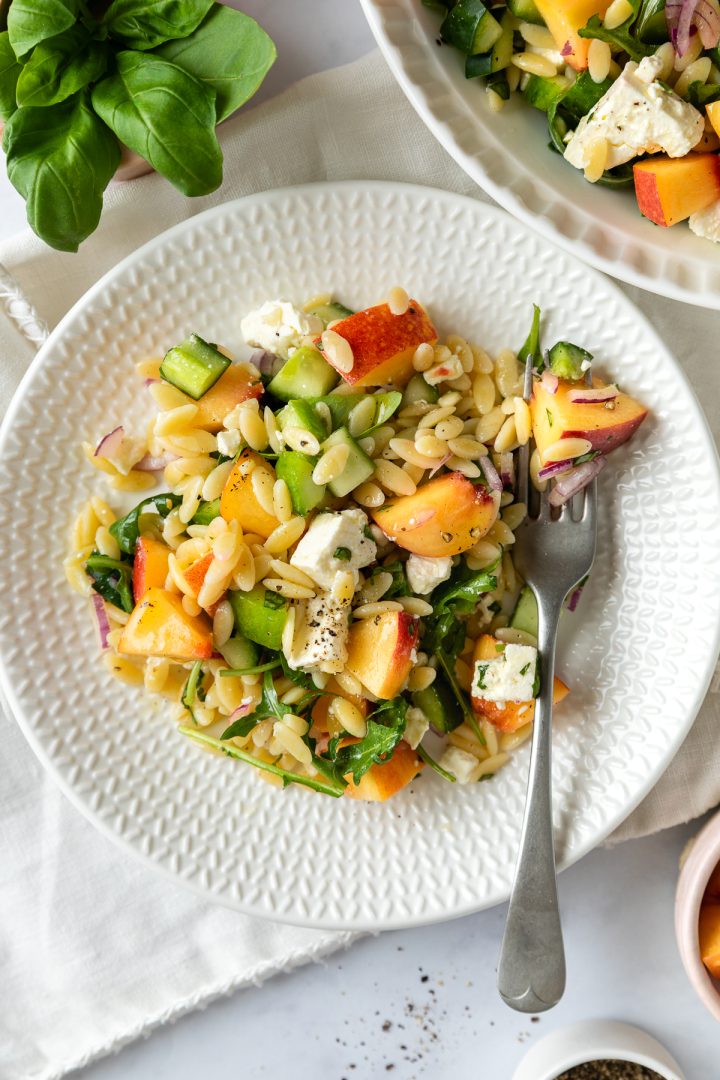 A portion of the peach salad on a white plate with a fork.