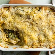 Tuna mornay in baking dish with a portion taken out to show the creamy pasta filling.