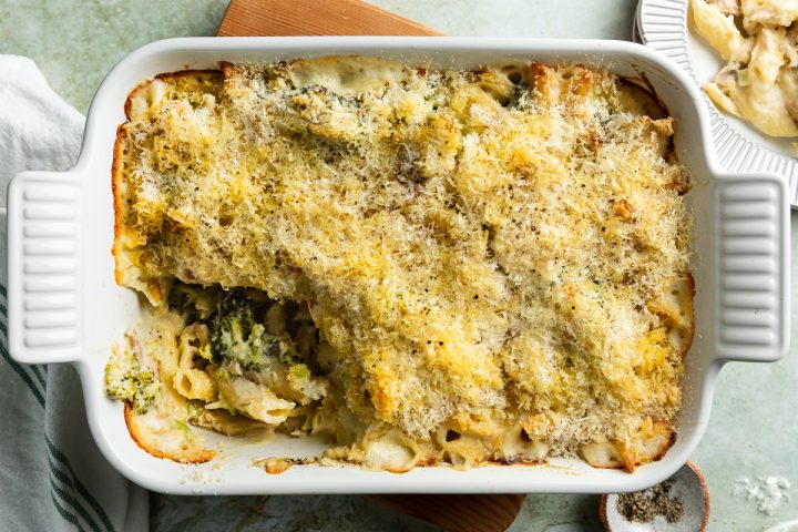 Tuna mornay in baking dish with a portion taken out to show the creamy pasta filling.