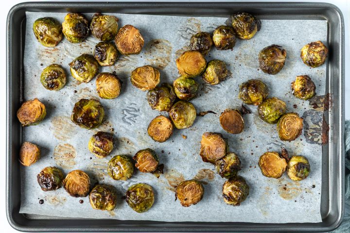 The sprouts on the lined tray once roasted in the oven.