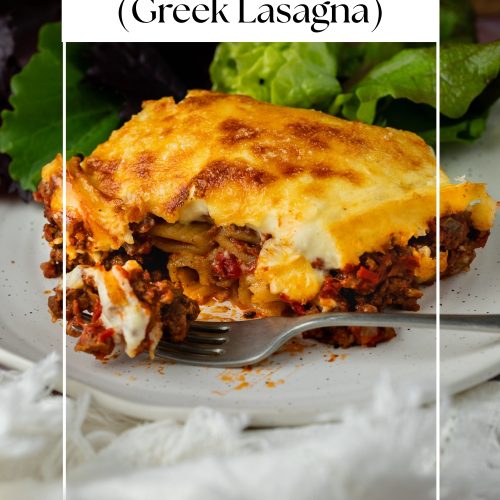 A portion of Pastitsio on a plate with a fork, with text overlay to create a pin for Pinterest.