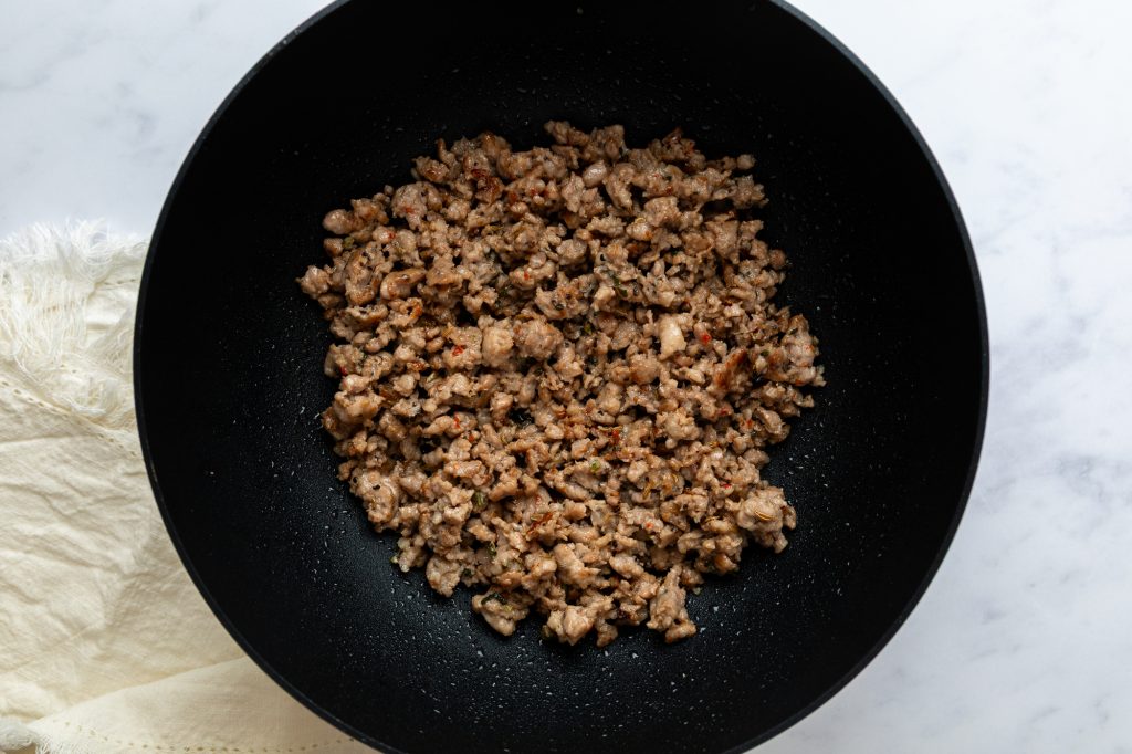 The browned sausage meat in the pan.