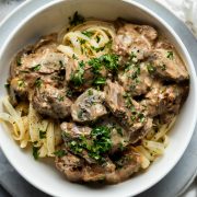 A bowl of beef stroganoff served on pasta.