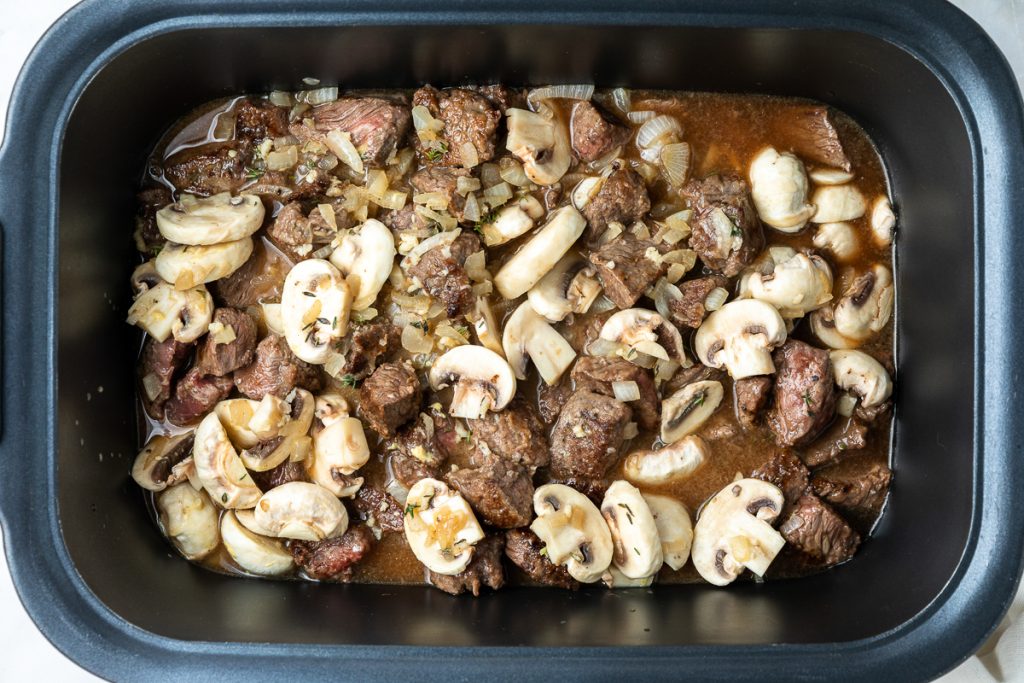 All the ingredients in a slow cooker ready to be cooked.