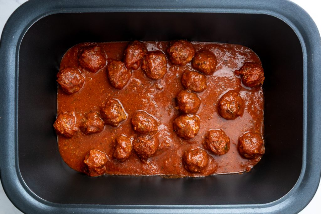 The cooked meatballs in the slow cooker.