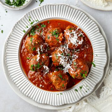 A plate of slow cooker meatballs sprinkled with parsley.