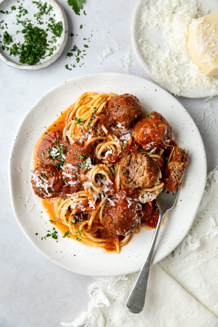 A plate of meatballs with one halved to show the texture.