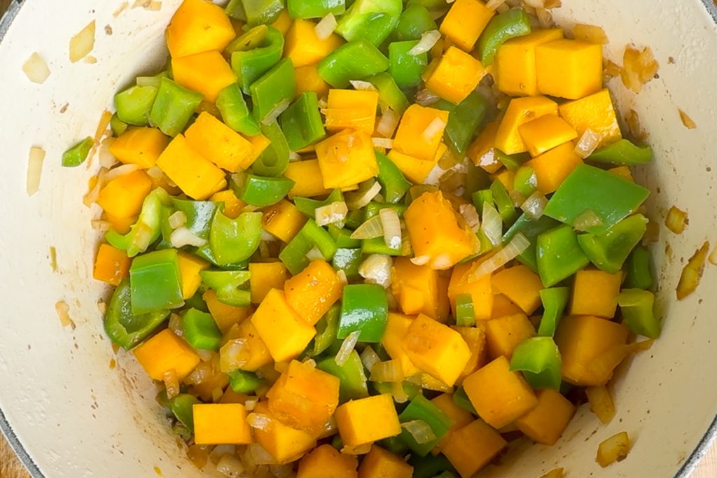 The softened vegetables in a pan.