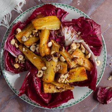 Parsnip salad on a plate with small radicchio leaves on the background to the right hand side.