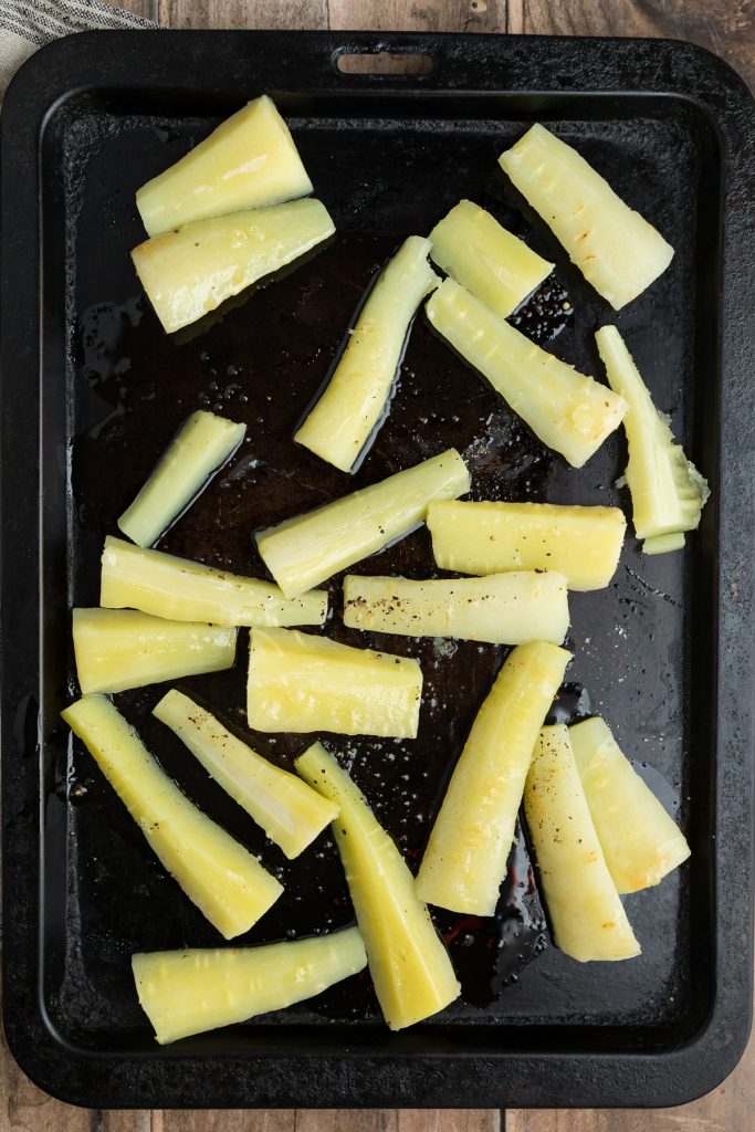 Boiled parsnips on a baking tray.