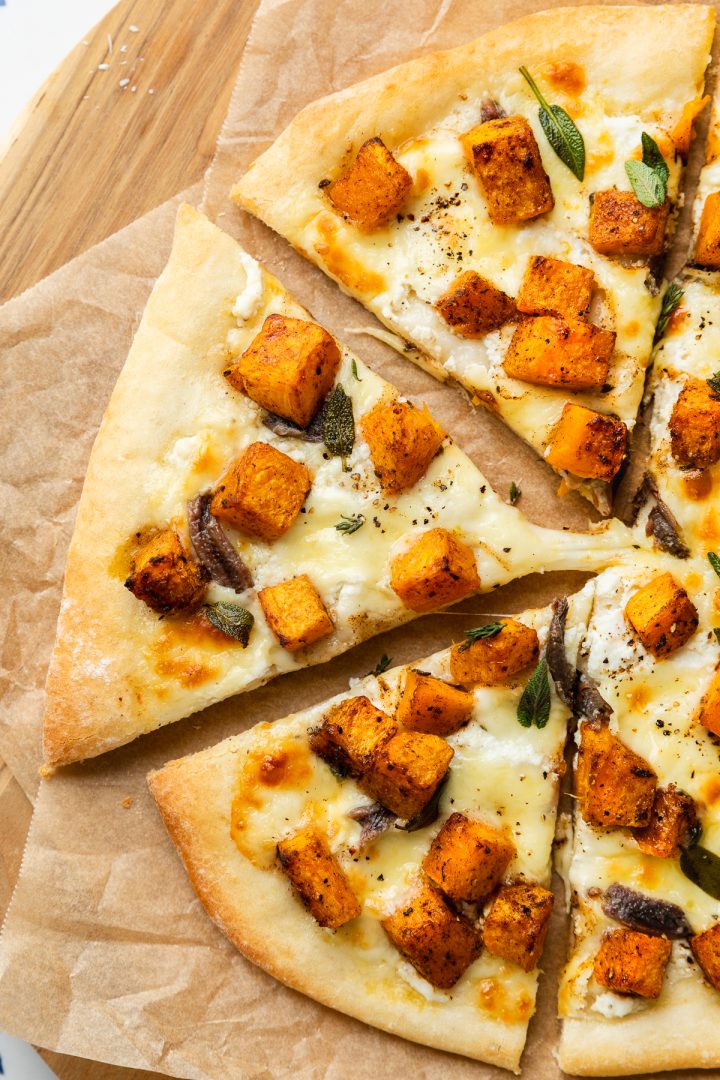 Close up of the finished butternut pizza with a gooey cheese pull.