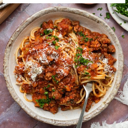 A bowl of spaghetti bolognese with a text overlay to create a pin for Pinterest.