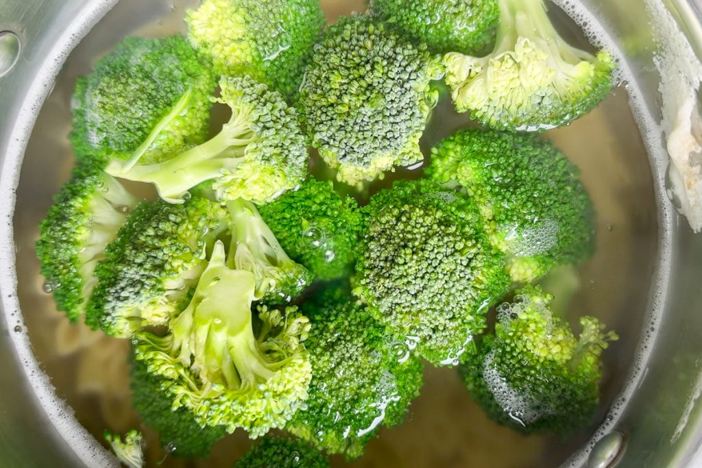 Broccoli florets cooking in the same pan as the pasta.