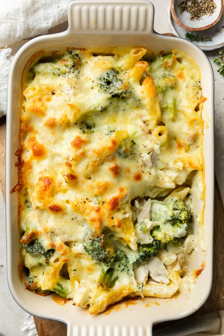 A close up of the chicken pasta bake with a section of the cheese topping taken out to show the creamy pasta underneath.