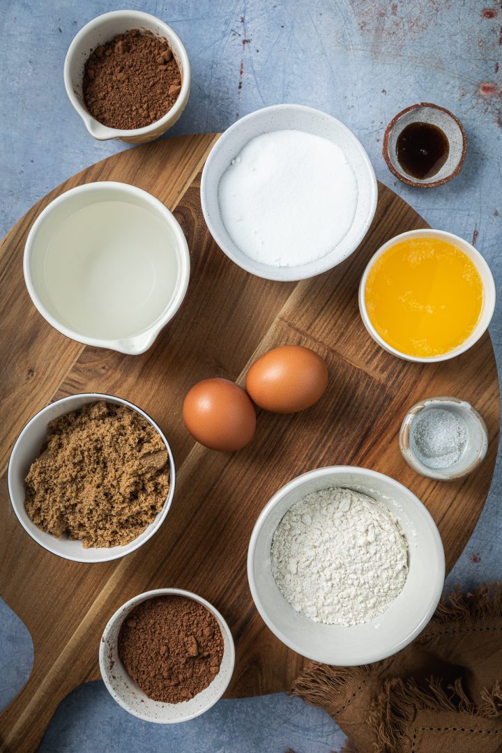 The ingredients needed to make the recipe weighed out and placed in individual bowls on a wooden board.