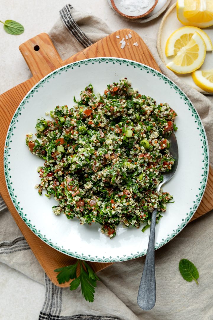 A plate of quinoa salad with a spoon ready to serve.