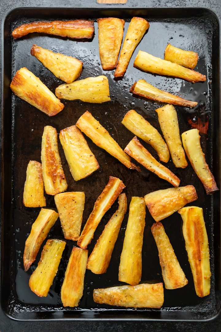 Roasted parsnips on a baking tray.