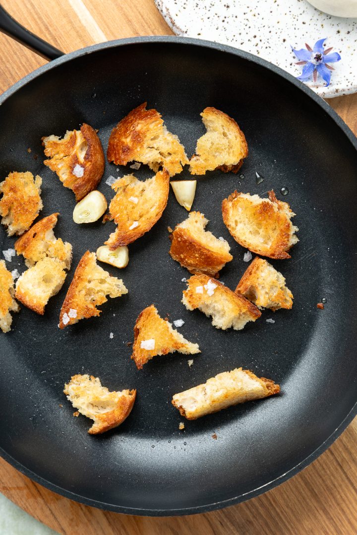 Sourdough croutons in a pan sprinkled with flaked salt