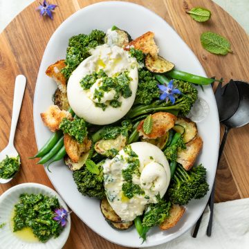 Burrata salad with spring vegetables topped with salsa verde.