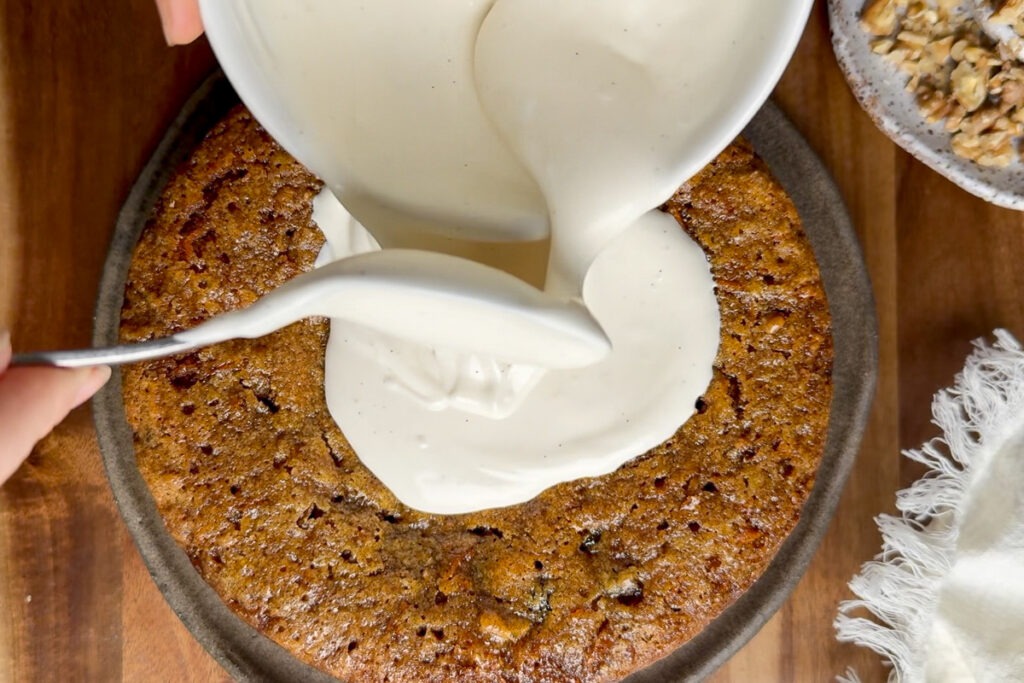 The mascarpone icing being poured over the cake.