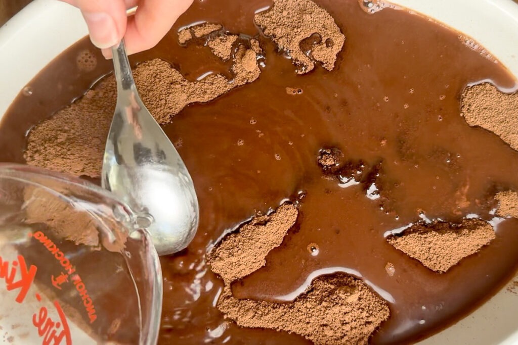 Water being poured over a spoon onto teh pudding.