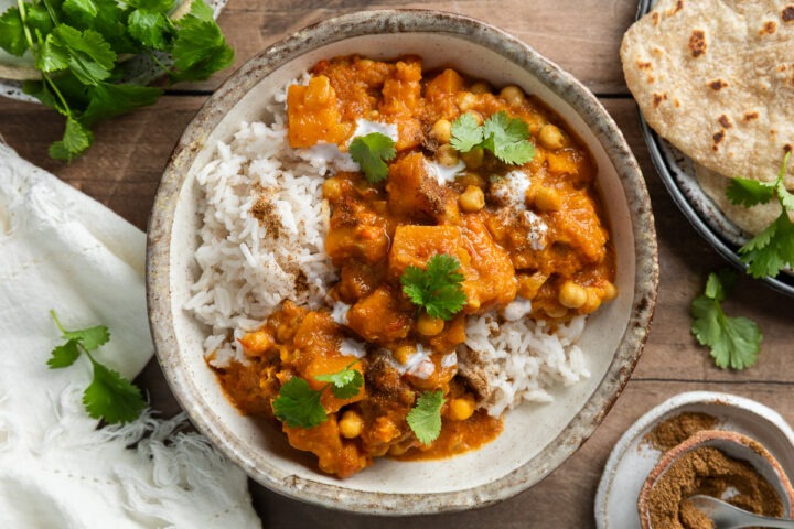 A bowl of butternut and chickpea curry served with rice.