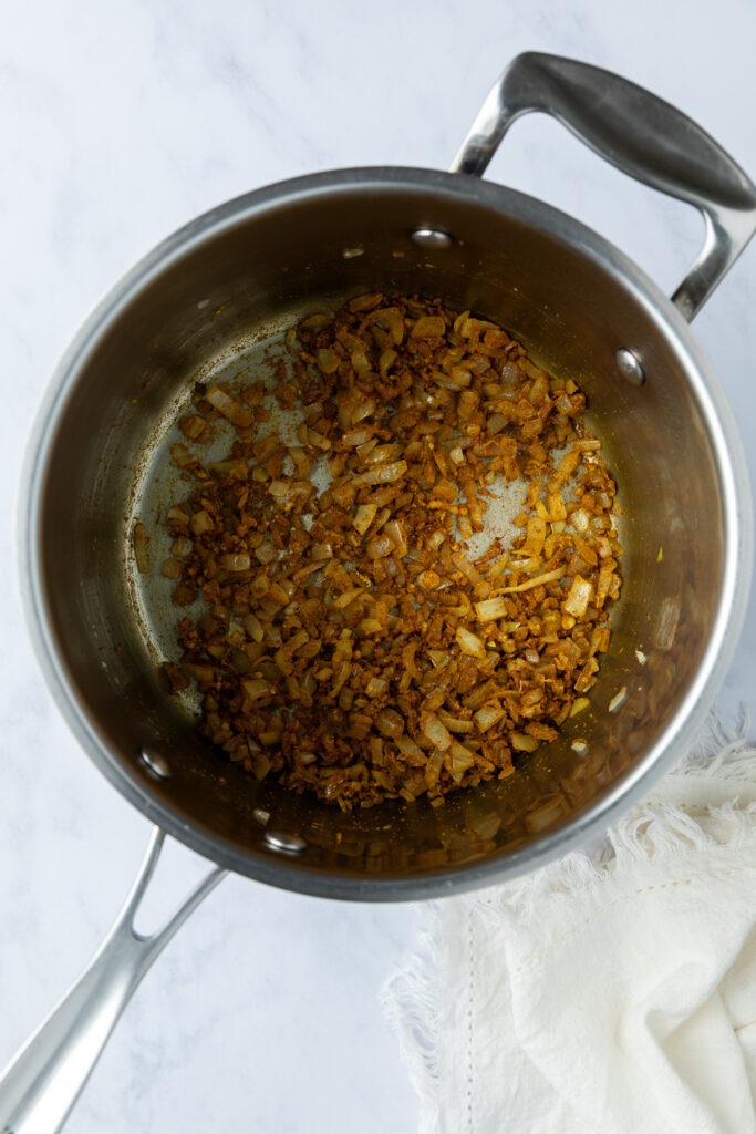The cooked onion, aromatics and spices in the saucepan.