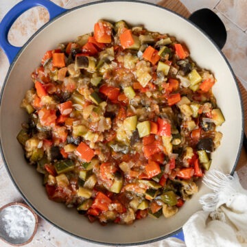 A pan of the cooked vegetables, with a plate of toasted bread on the side to serve with it.