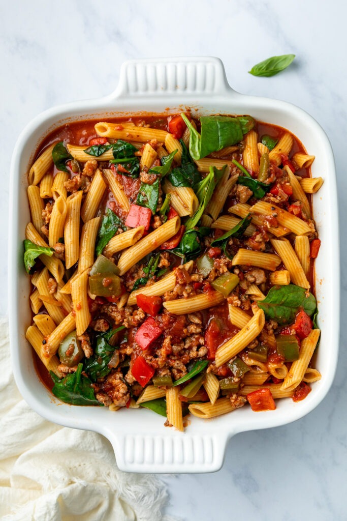 The cooked pasta combined with the sausages and tomato sauce and poured into an oven proof dish.