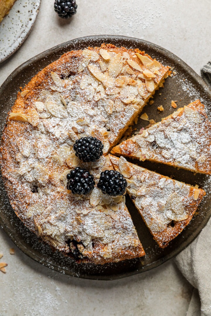 Close up overhead photo of the top of the homemade blackberry almond cake with a portion cut out.