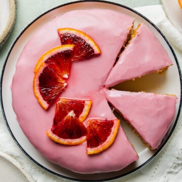 Overhead photo of homemade blood orange and almond cake topped with blood orange icing.