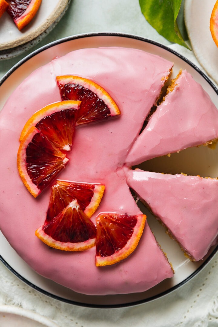 Overhead photo of a homemade blood orange cake topped with slices of fresh blood orange.