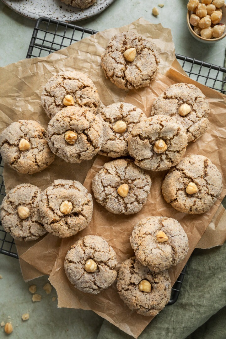 A batch pf freshly made hazelnut cookies on a cooling rack.
